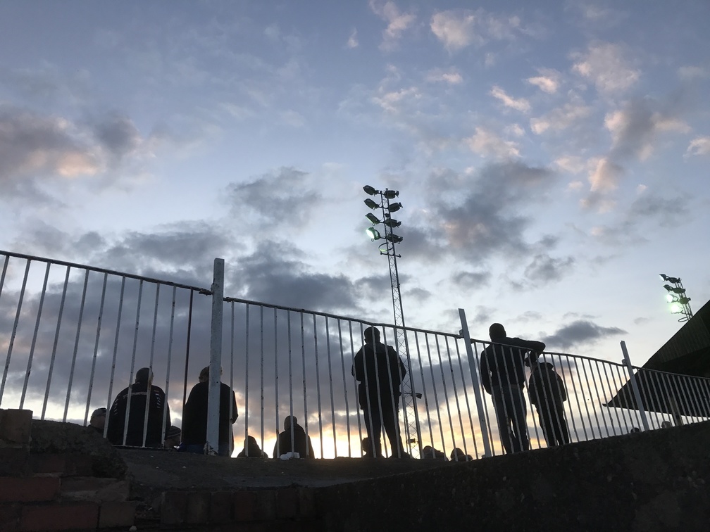 Looking up at people silhouetted against the sky on a sports stand